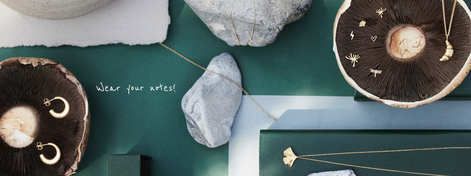 various gold jewellery in a beautiful lay up with mushrooms and rocks that compliment and is a gorgeous contrast to the exclusive gold jewellery